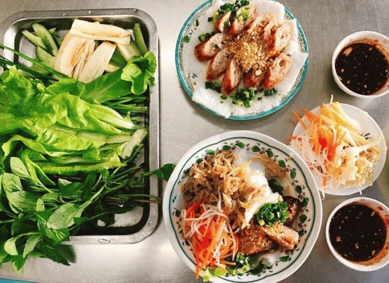 A variety of Vietnamese dishes including spring rolls, rice noodles, and fresh vegetables. 2