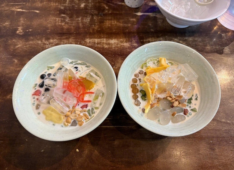 Two bowls of dessert with various fruits and nuts on a wooden table. 3