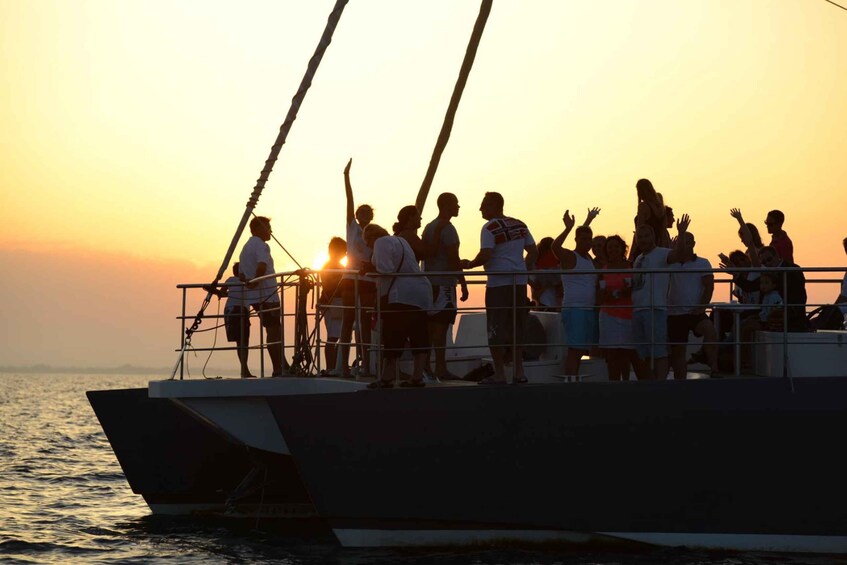 A group of people on a boat at sunset. 3