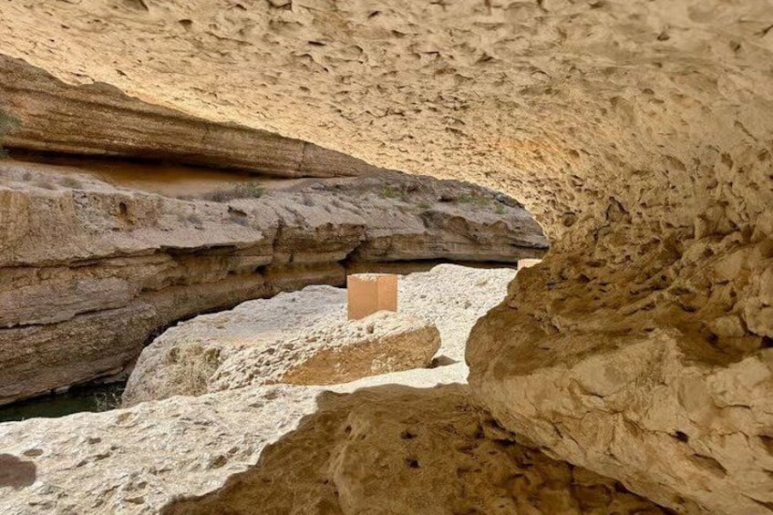 A rock formation with a cave-like structure and a wooden box. 5
