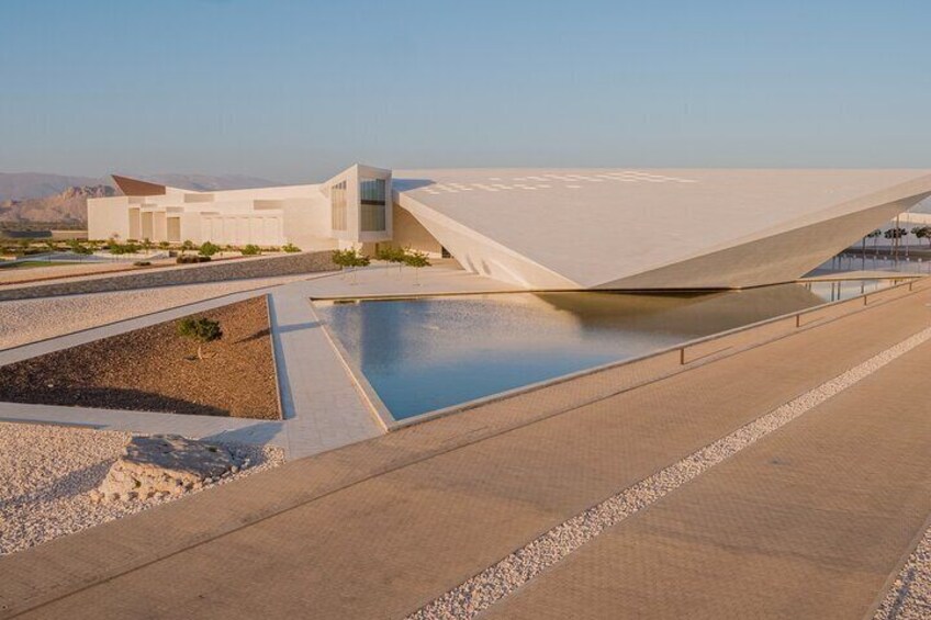 A modern architectural structure with a pool and desert landscape. 4