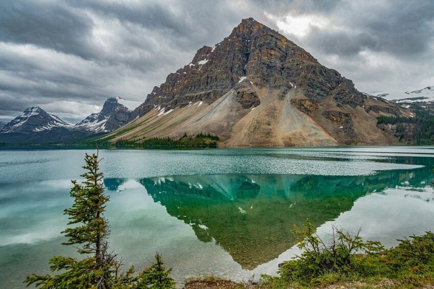 Un lago de montaña con reflejos nítidos, rodeado de árboles y montañas. 4
