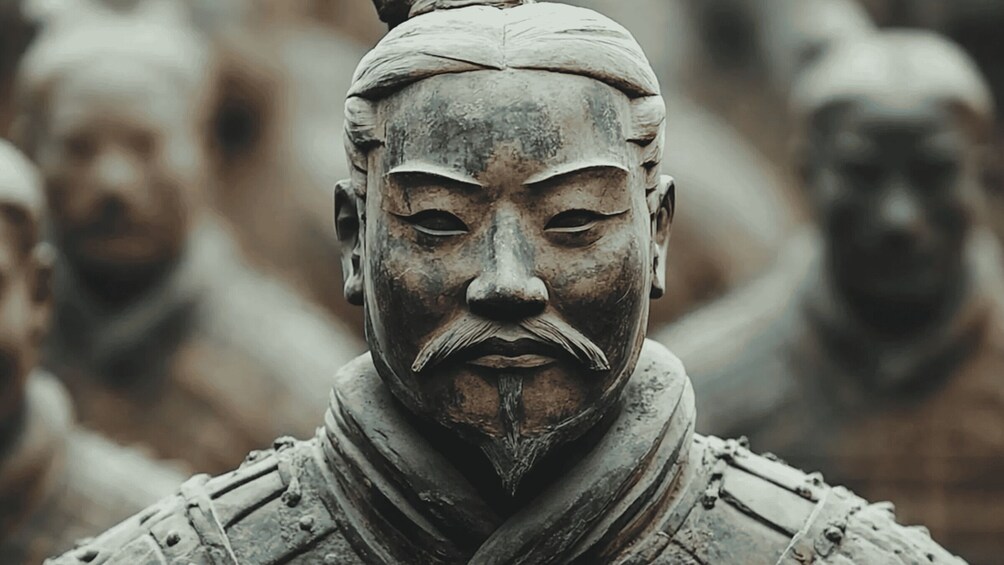 A close-up of a weathered statue with a detailed headdress and armor. 3