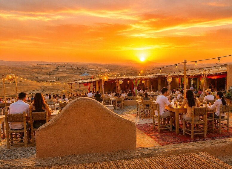 A sunset at a restaurant with outdoor seating overlooking a hilly landscape. 1