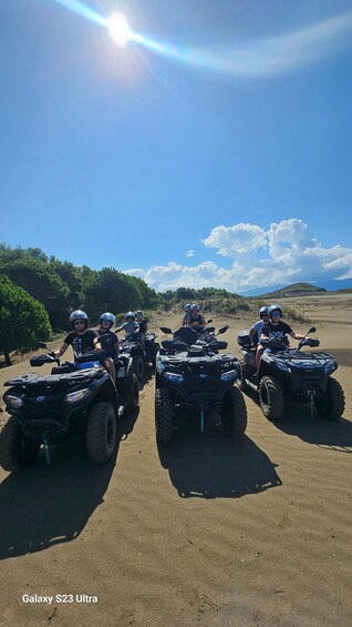 Four people on ATVs in a desert landscape with a clear sky. 1