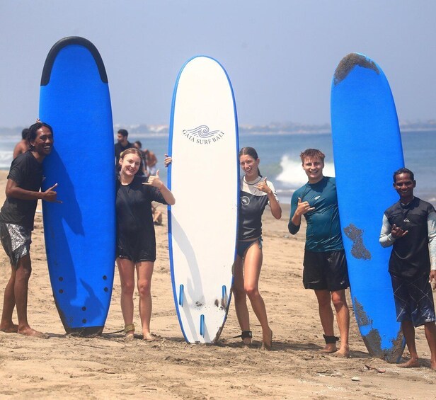 A group of people on a beach holding surfboards. 5