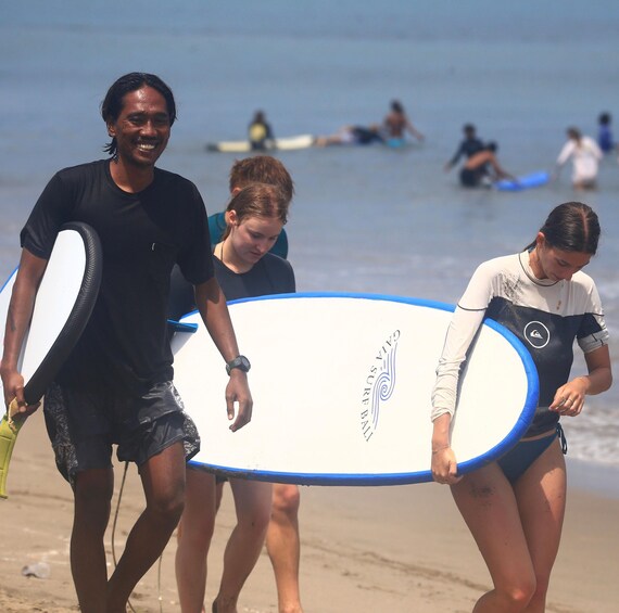 A beach scene with people carrying surfboards. 5