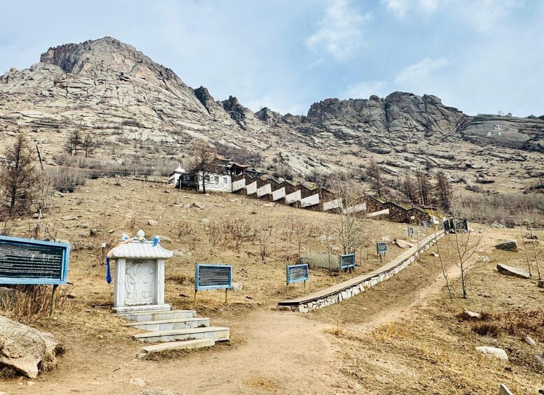 A mountainous landscape with a pathway leading to a traditional building. 4