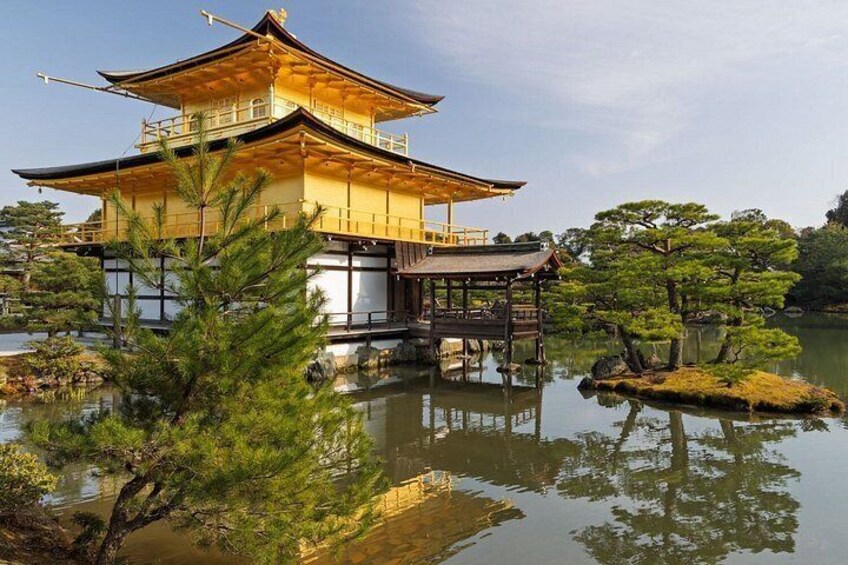 A traditional Japanese pagoda with a reflection in the water, surrounded by pine trees and a small island. 1