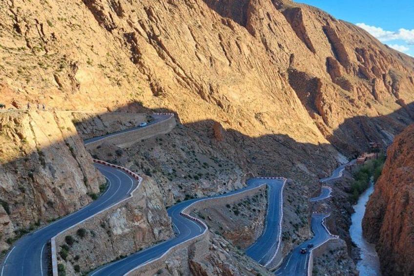 A winding mountain road with sharp bends and rocky terrain. 4