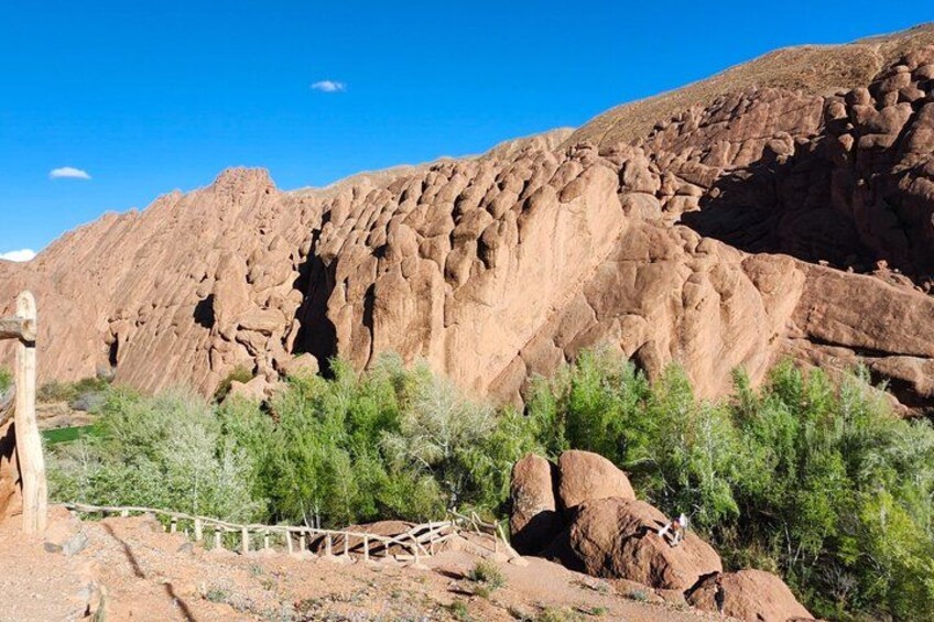 A rocky desert landscape with a wooden fence and sparse vegetation. 5