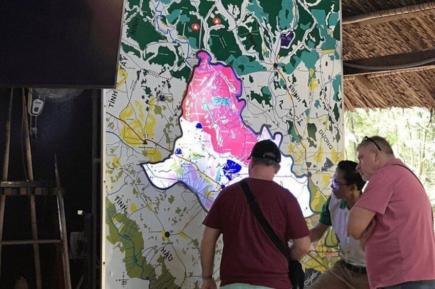 Un gran mapa con diferentes zonas de colores y una escalera apoyada en él. 5