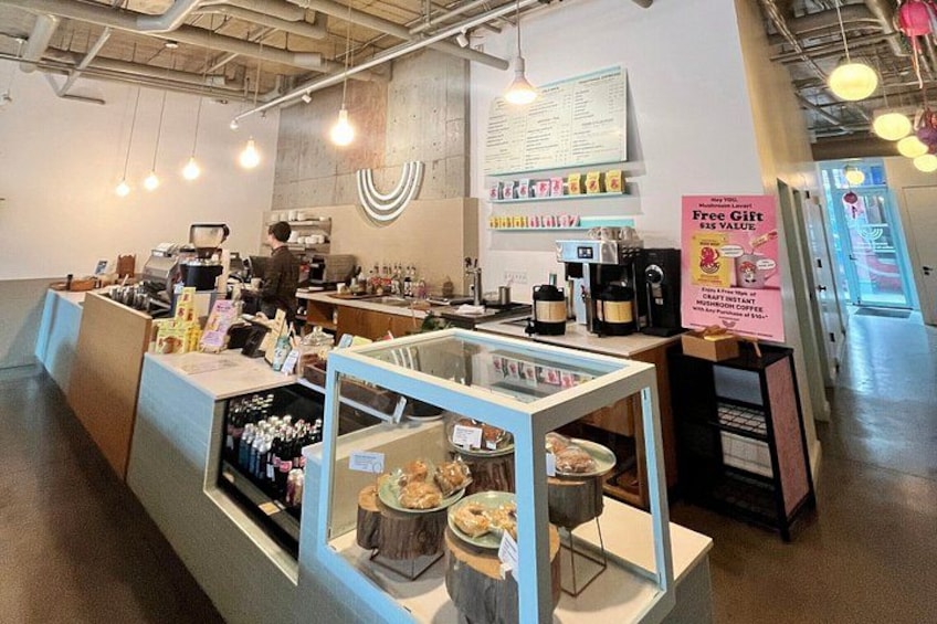 A cafe interior with a counter, coffee machines, and a menu board. 3