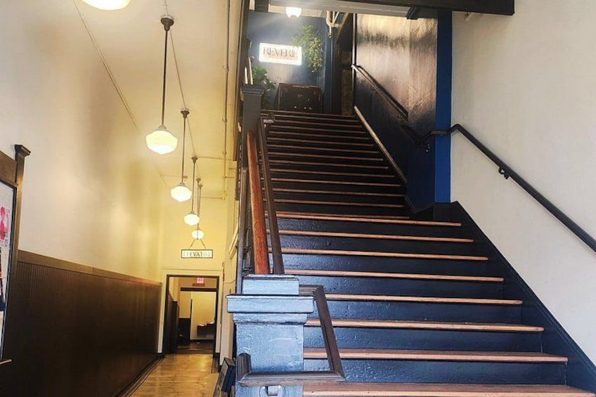 A staircase with wooden steps and metal railings, leading to an upper floor. 4