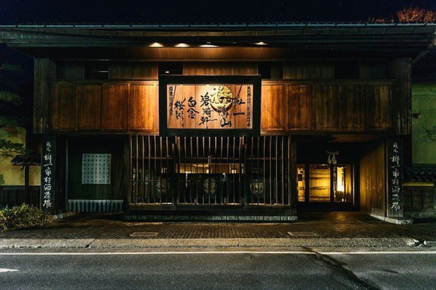 A traditional Japanese building with wooden architecture and a signboard with Japanese characters. 5