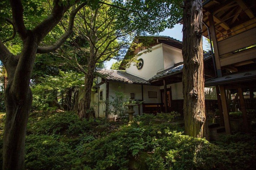 A traditional Japanese building surrounded by lush greenery. 1