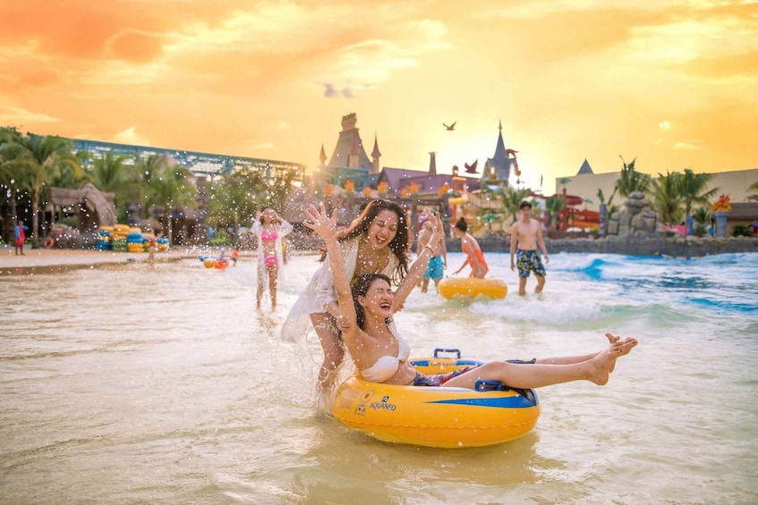 People on water tubes at a water park with a sunset sky. 1