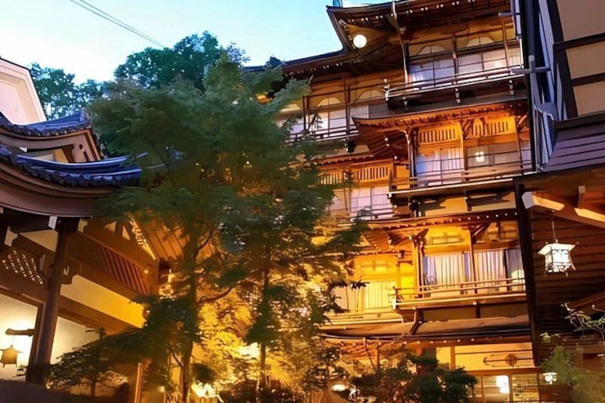 Un edificio japonés tradicional con varios balcones y un árbol en primer plano. 3