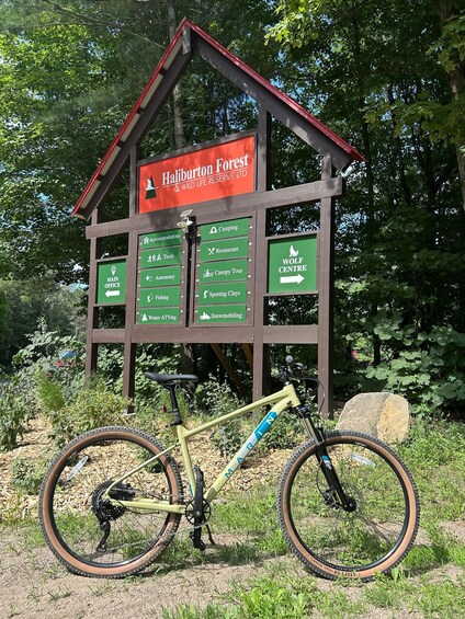 A wooden signpost with directions to various activities like camping, trails, and a wolf center. 1
