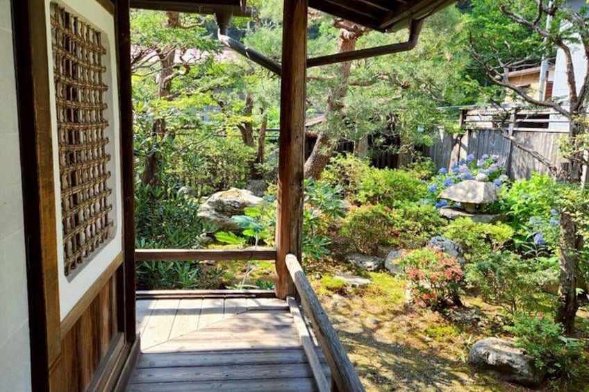A wooden staircase leading to a garden with rocks, plants, and a wooden fence. 3