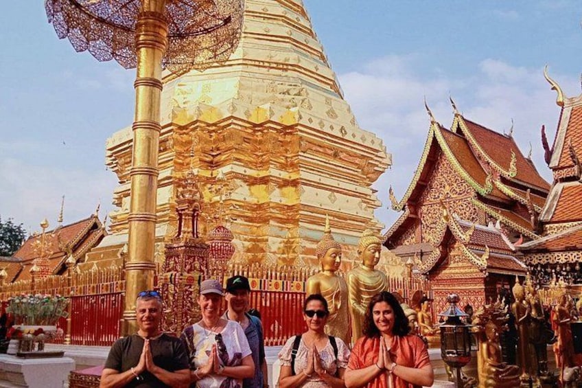 Un groupe de personnes se tient devant un grand temple richement décoré, orné de statues dorées et doté d’une architecture complexe. 5