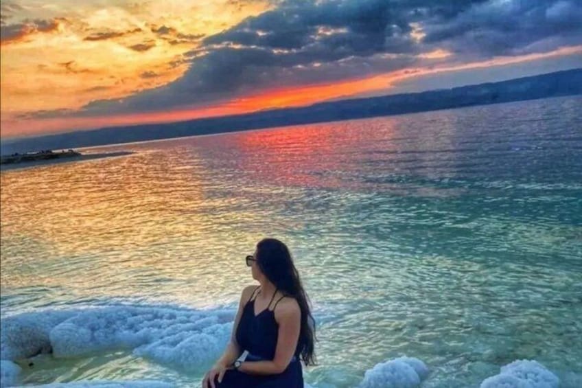 Une personne se tient près d’une étendue d’eau au coucher du soleil. 4