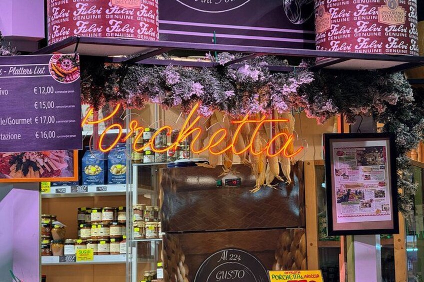 A storefront with a neon sign reading 'Porchetta' and a sign indicating a price of €16.00. 1