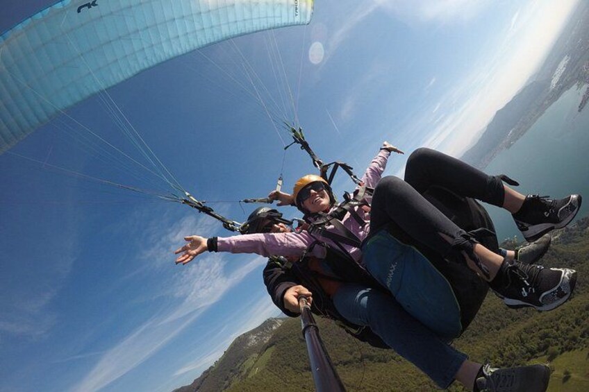 Una persona practicando parapente bajo un cielo despejado y un paisaje lejano. 2