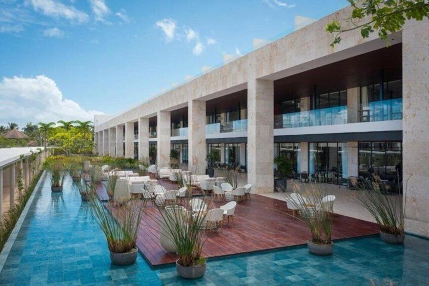 Un resort moderno con piscina, mobiliario exterior y un edificio de varios niveles. 4