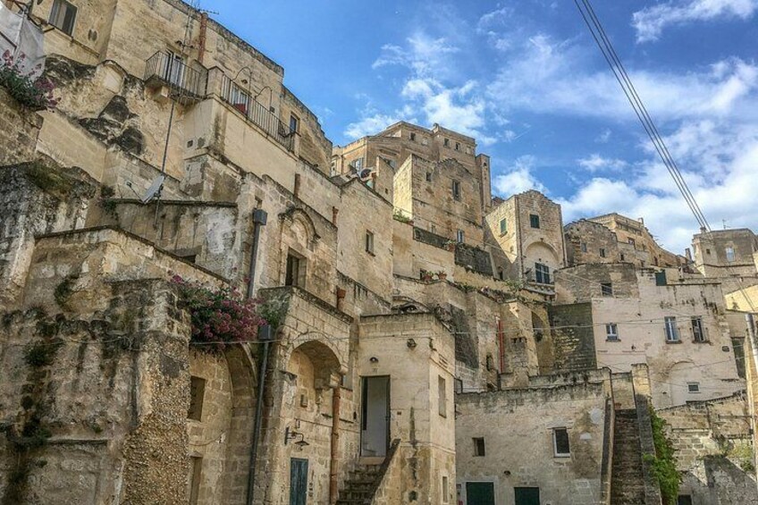 A historic stone building with multiple levels, arched doorways, and balconies. 4