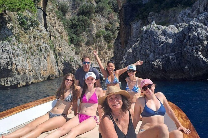 Un grupo de personas en un bote cerca de acantilados rocosos. 2