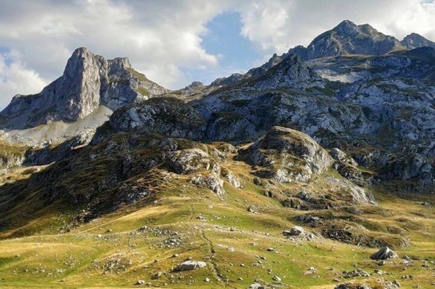 A mountainous landscape with rocky terrain and grassy areas. 4