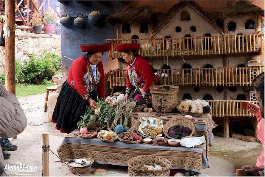 Two people in traditional attire preparing food at a market stall with various items displayed. 3