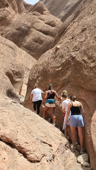 A group of people hiking in a rocky canyon. 1
