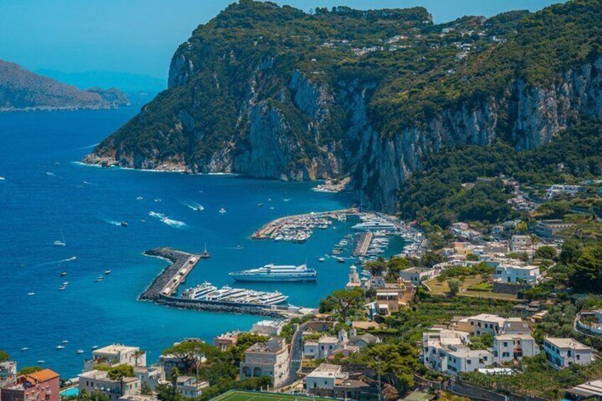 A coastal town with a marina, steep cliffs, and residential buildings. 3