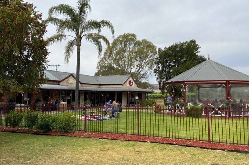 A building with a red roof, a fenced garden, and a gazebo. 3