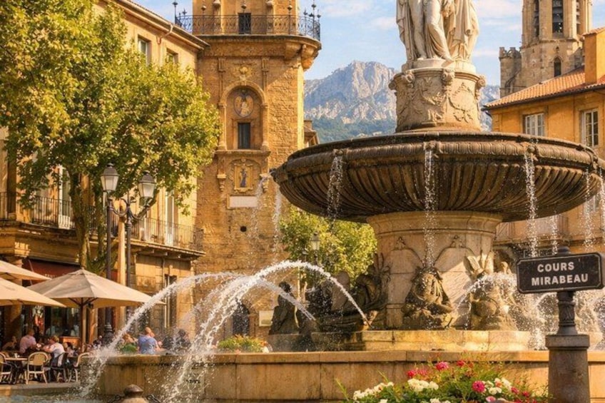 A fountain with water jets, a statue, and a sign reading 'Cours Mirabeau.' 3