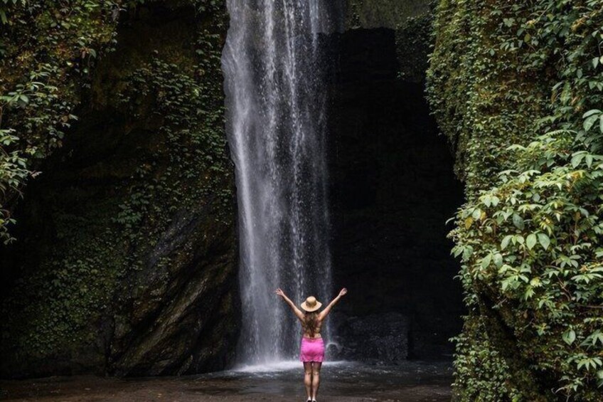 Une cascade avec une personne debout devant. 2
