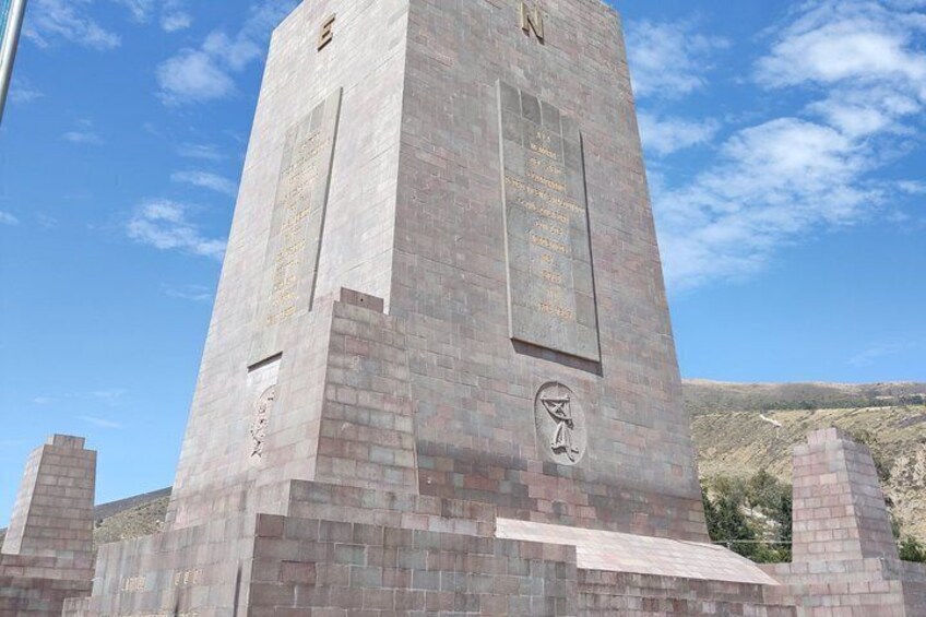 Un monumento alto y rectangular con inscripciones y un relieve escultórico en su base. 2