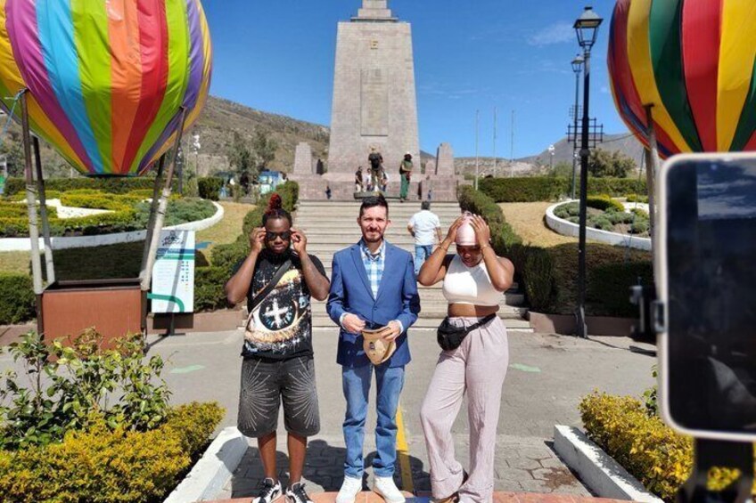 Tres personas frente a un monumento, con globos aerostáticos al fondo. 4