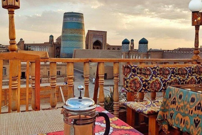 A rooftop terrace with a view of a cityscape, including a tall building and traditional architecture. 4