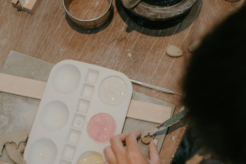 A person working with a silicone mold on a wooden surface, surrounded by various tools and materials. 1