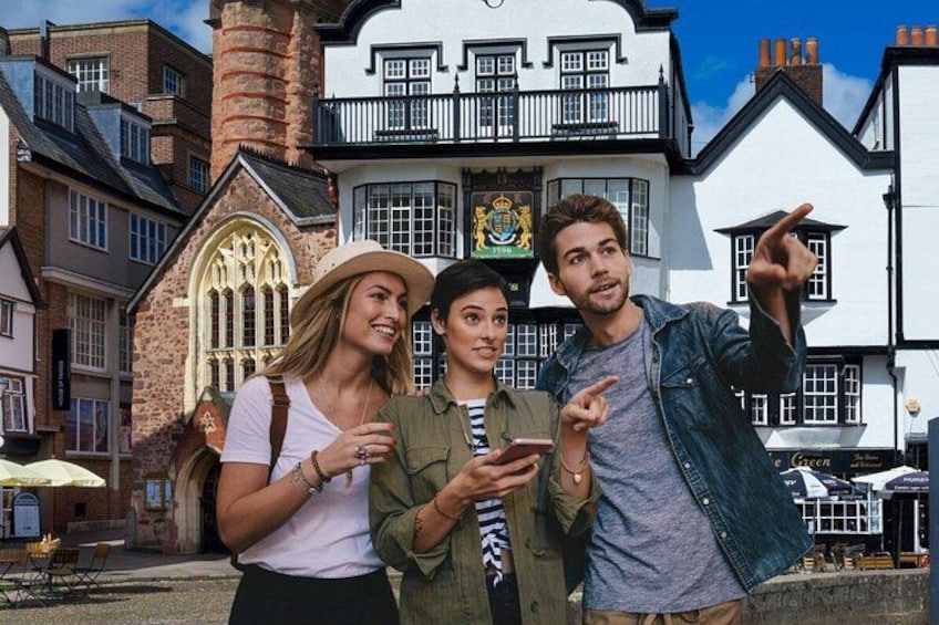 Three people in front of a historic building with a prominent sign. 1