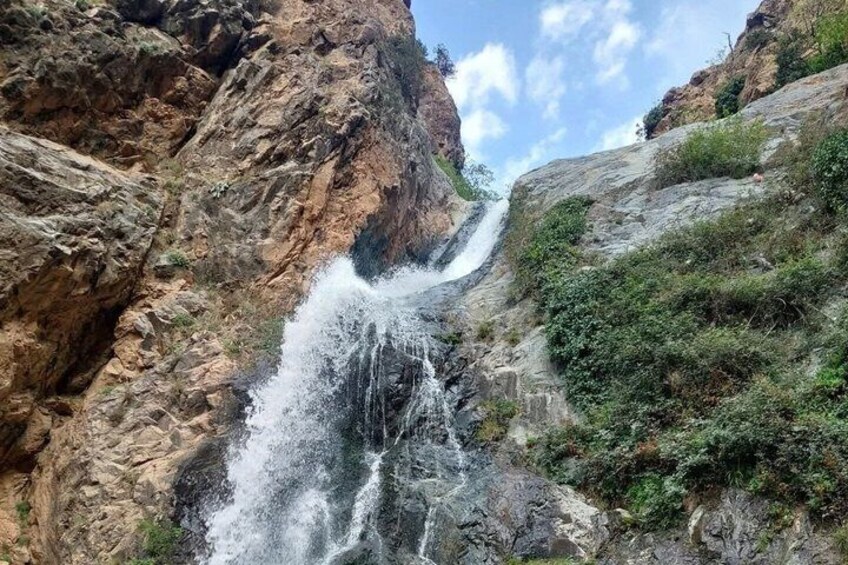 Une cascade se déversant le long d’une falaise rocheuse, entourée d’une végétation luxuriante. 1