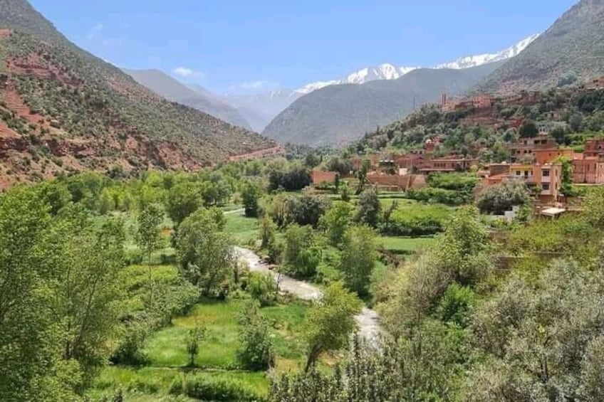 Un paysage montagneux avec un village niché au milieu de champs verdoyants et traversé par une rivière. 4