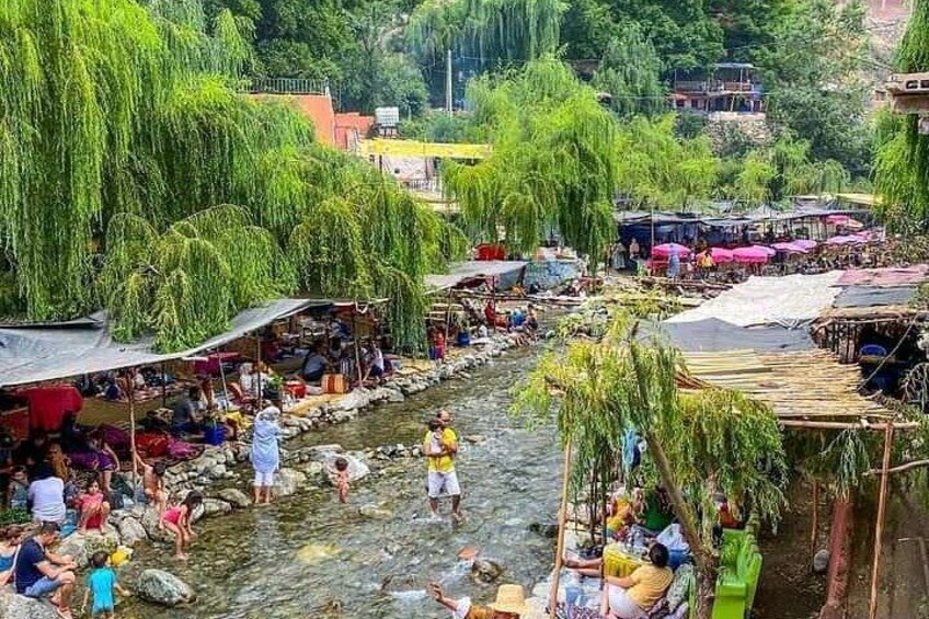 A riverside market with people and boats. 3