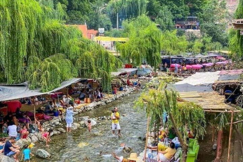 Un marché au bord de la rivière, animé par la présence de personnes et de bateaux. 3