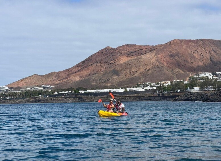 A yellow kayak on calm water with a mountainous landscape in the background. 2