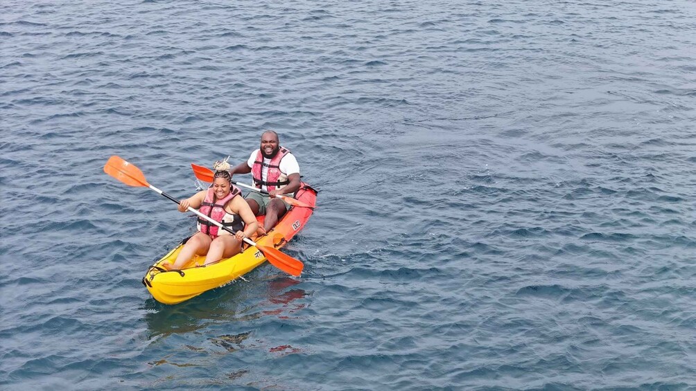 Two people kayaking on a calm sea. 5