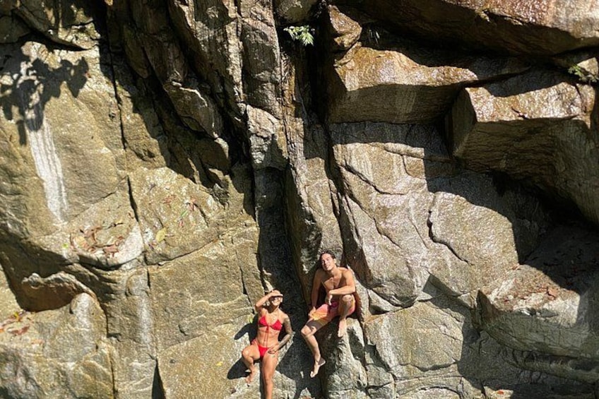 Two people sitting on a rocky cliff. 3